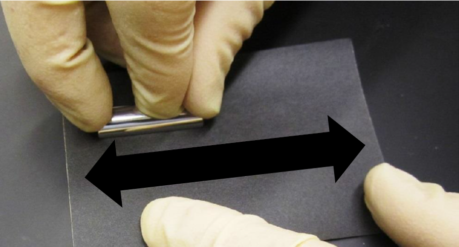 A close-up of hands in gloves holding a metal object  Description automatically generated